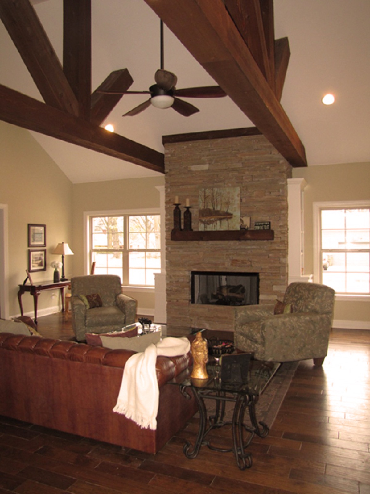Custom great room with stone fireplace and timber beams built by Renaissance Homes