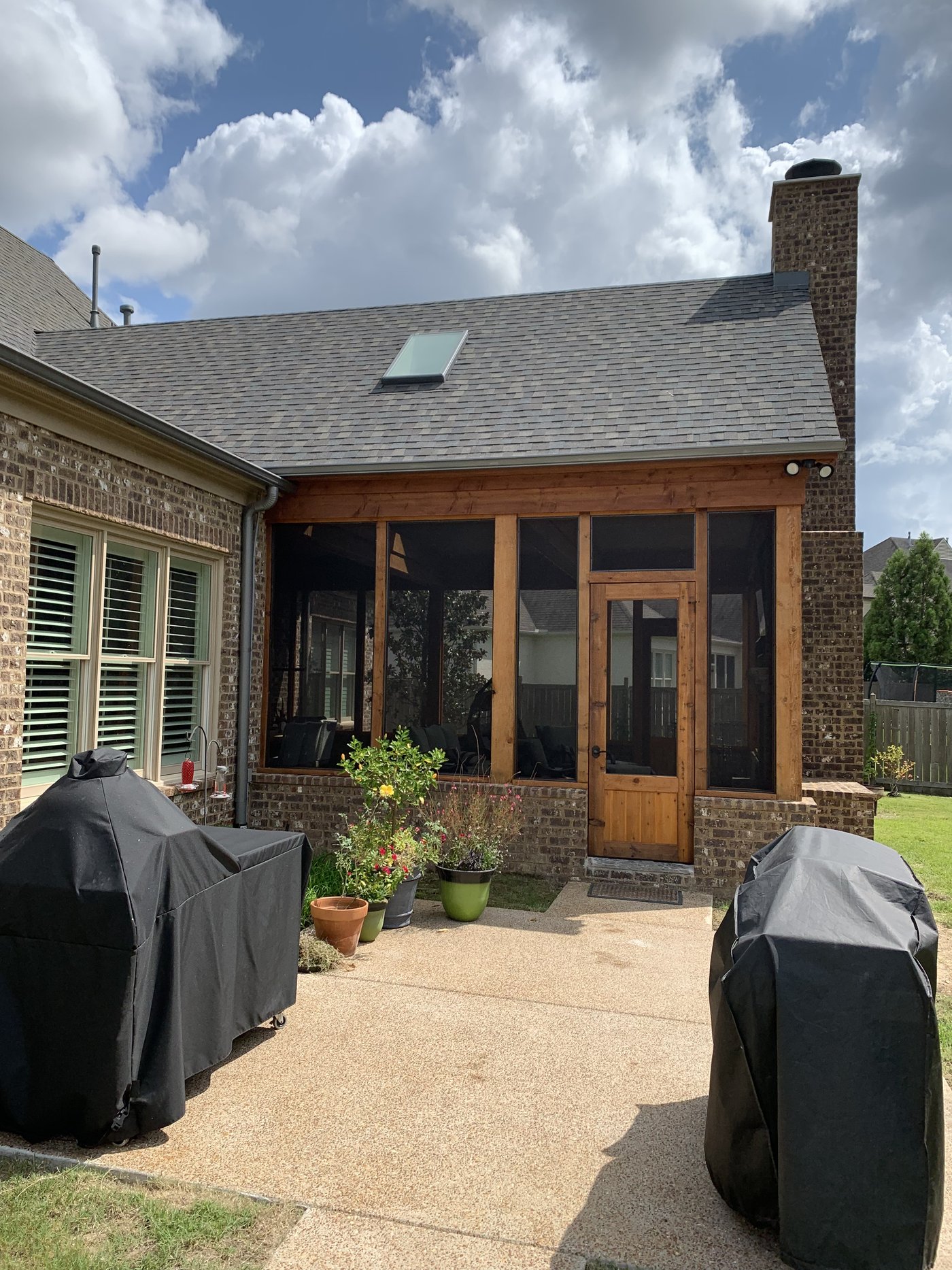Finished screened porch addition with wood trim and stone patio