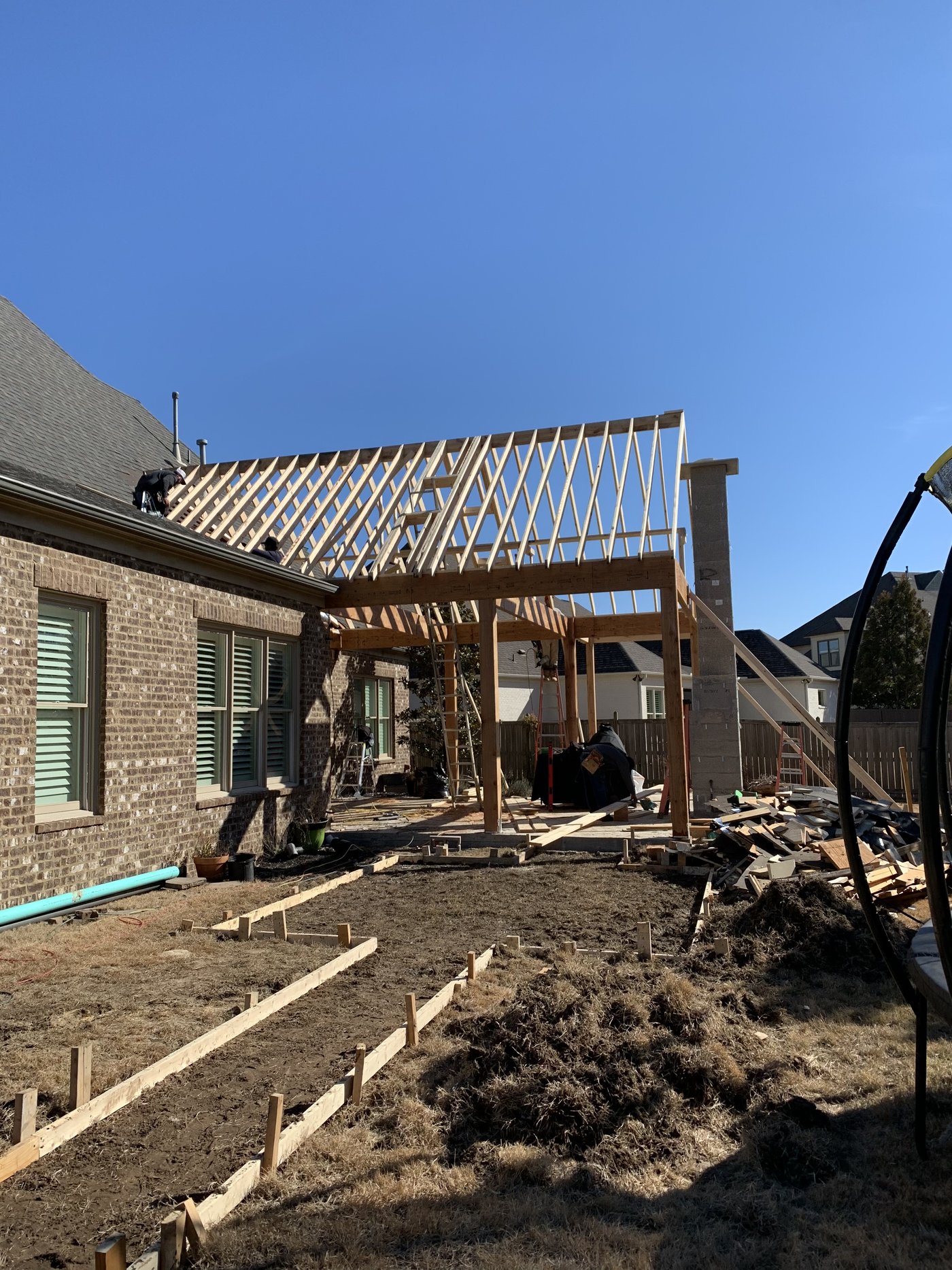 Screened porch addition under construction, roof framing in progress